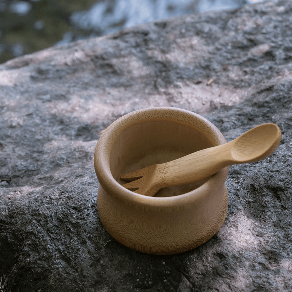 A bamboo Kids Spork rests in a baby bowl.