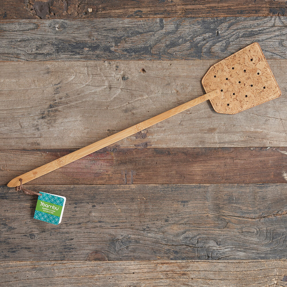 A Bamboo & Cork Fly Swatter rests on a wooden table - bambu