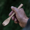 A person holds a Large Spork in their right hand.