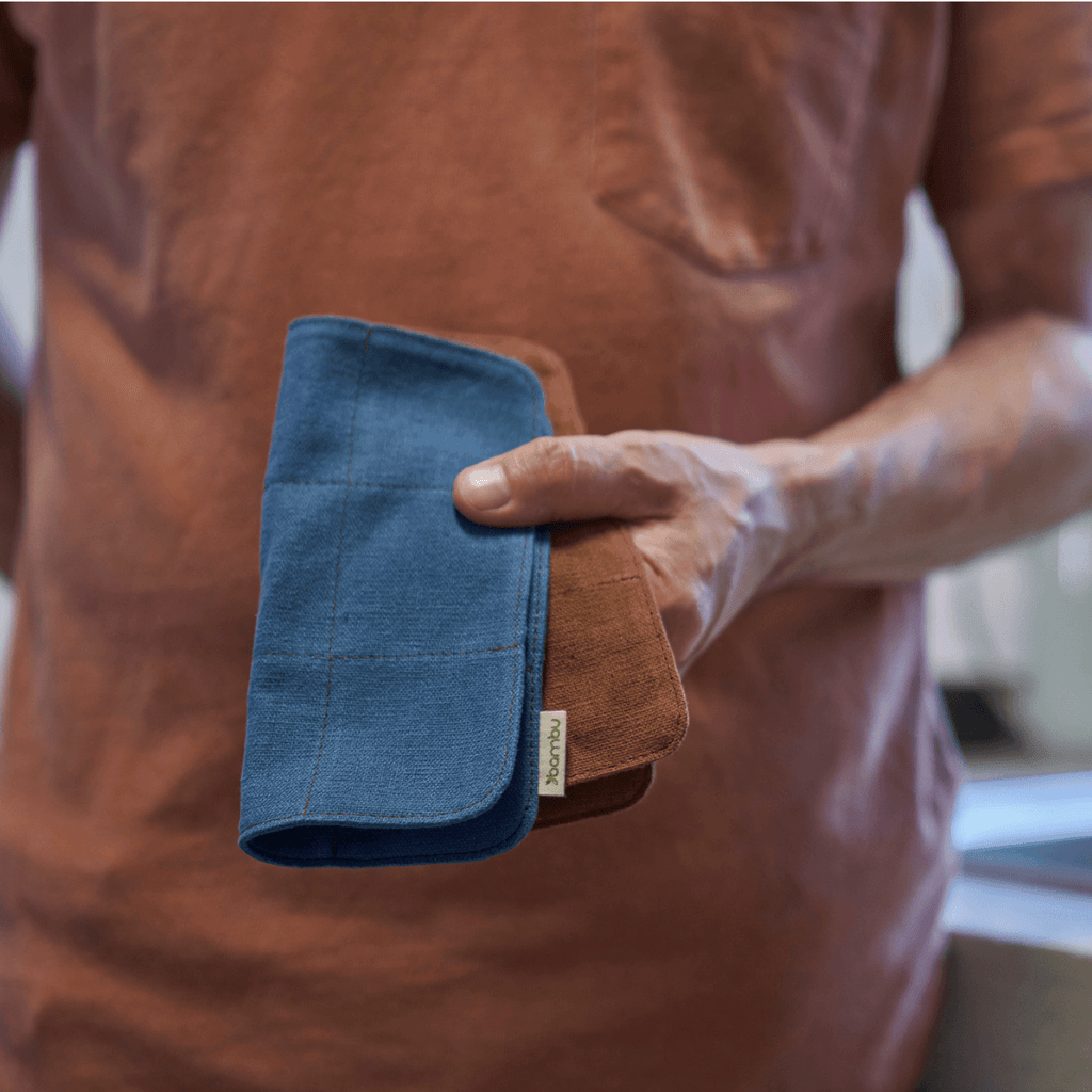A person holds a set of dishcloths in both Teal and Nutmeg 