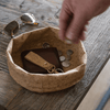 cork fabric bowl used as a key and wallet catch-all on a wooden table.