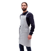 A man wears a MEEMA upcycled denim apron in blue.