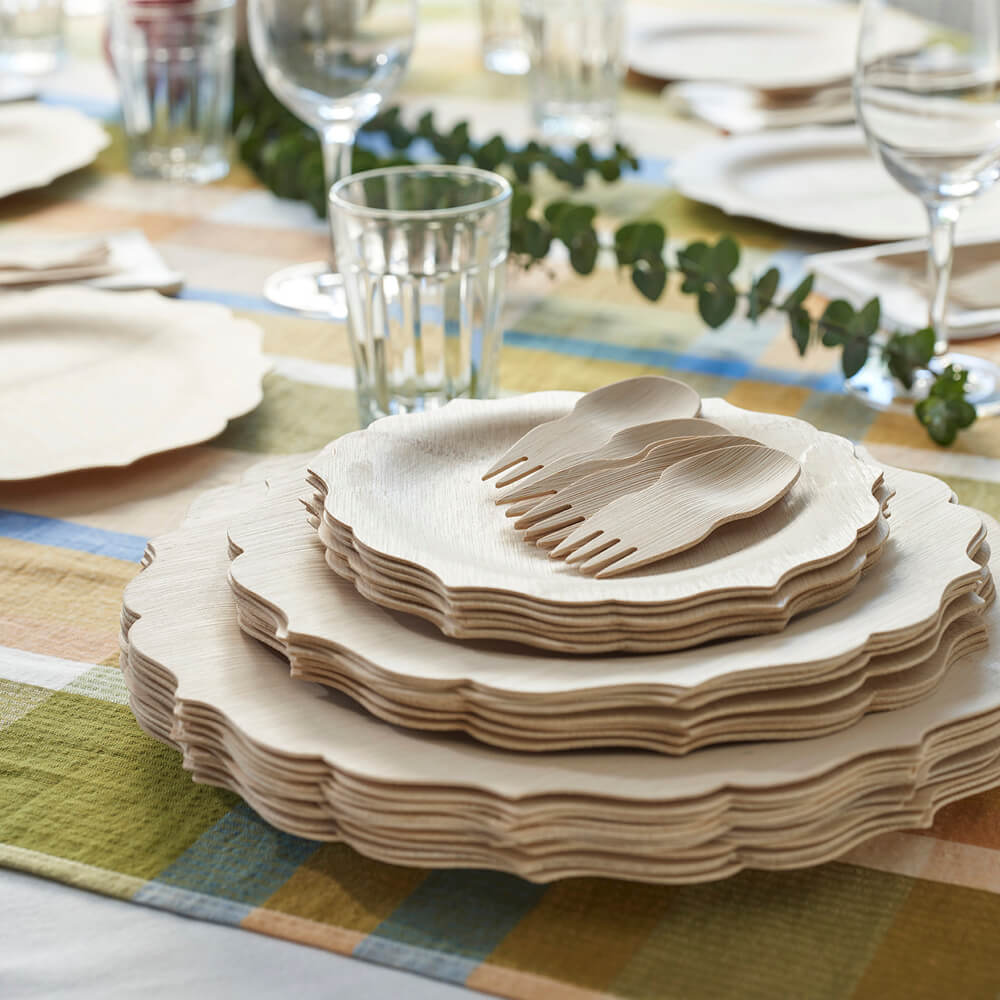 Veneerware® Fancy Bamboo Plates in all 3 sizes are stacked on a table. There are several sporks on top of the stack.