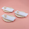 Three 9" Veneerware® Fancy Bamboo Plates are on a pink tablecloth. Each plate has a folded napkin atop with a set of Veneerware cutlery tucked into the napkin.