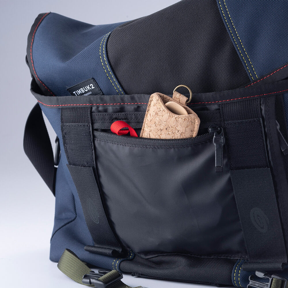 A Spork & Cork set is tucked into a pocket on a cross-body tote bag.