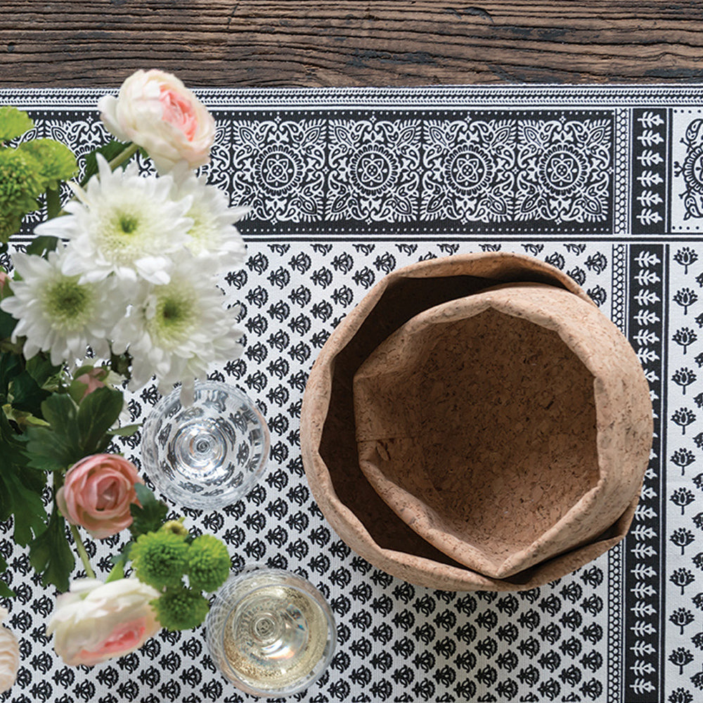 cork fabric bowls are nested on a table with flowers.
